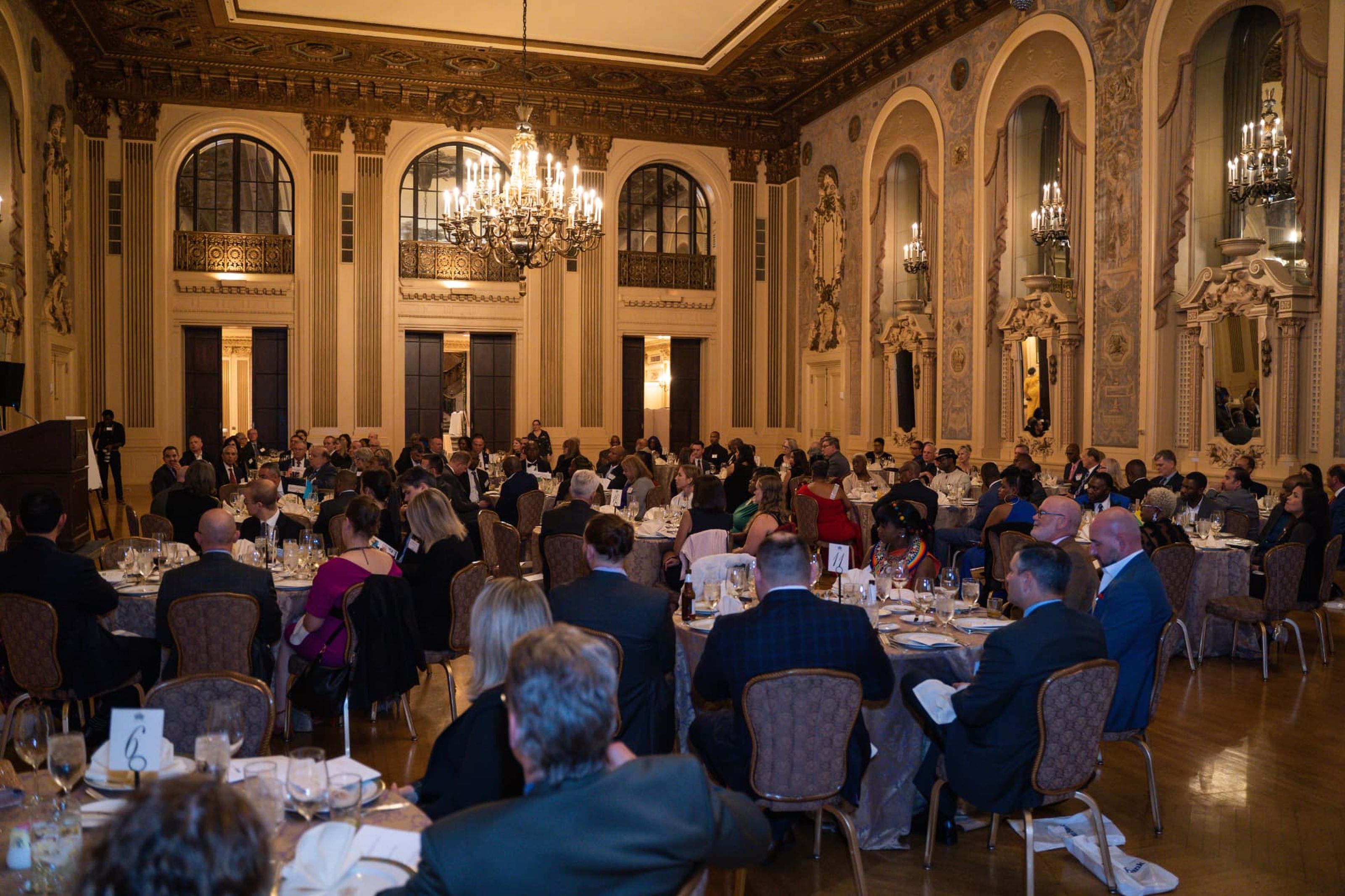 Guests seated at banquet tables in an ornate ballroom